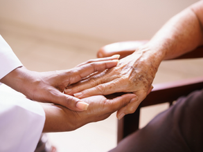 La mano de una doctora sosteniendo la de una adulta mayor, transmitiendo seguridad y soporte.