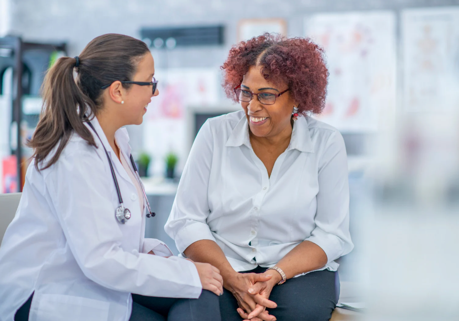 Una paciente conversando feliz con su doctora.