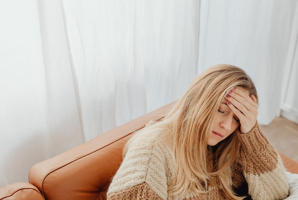 Mujer joven sosteniéndose la cabeza en señal de dolor