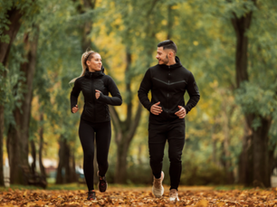 Una pareja de adultos trotando en el bosque.