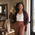 Confident Black woman standing near a bright window, reflecting during a season of personal change.