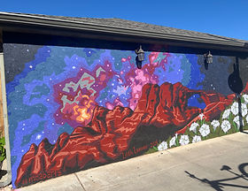 Image is of a painted mural on the west side of the Bowen motel featuring an arch with a starry sky in the background and moonflowers in the foreground. 