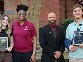 James Logan Bass and Madison Kerry hold their Student-Athlete of the Year Plaques as they stand with their coaches.