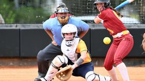 Salkehatchie softball player at bat with ball crossing the plate.