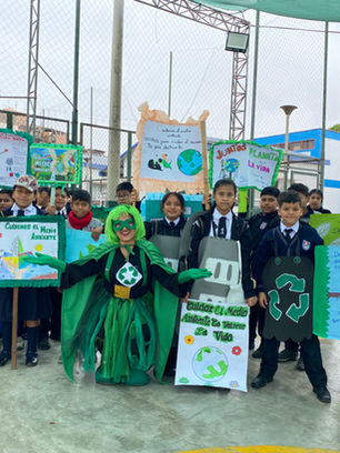 Grupo de estudiantes sonriendo directo a la cámara en una activación por el día del medio ambiente. 
