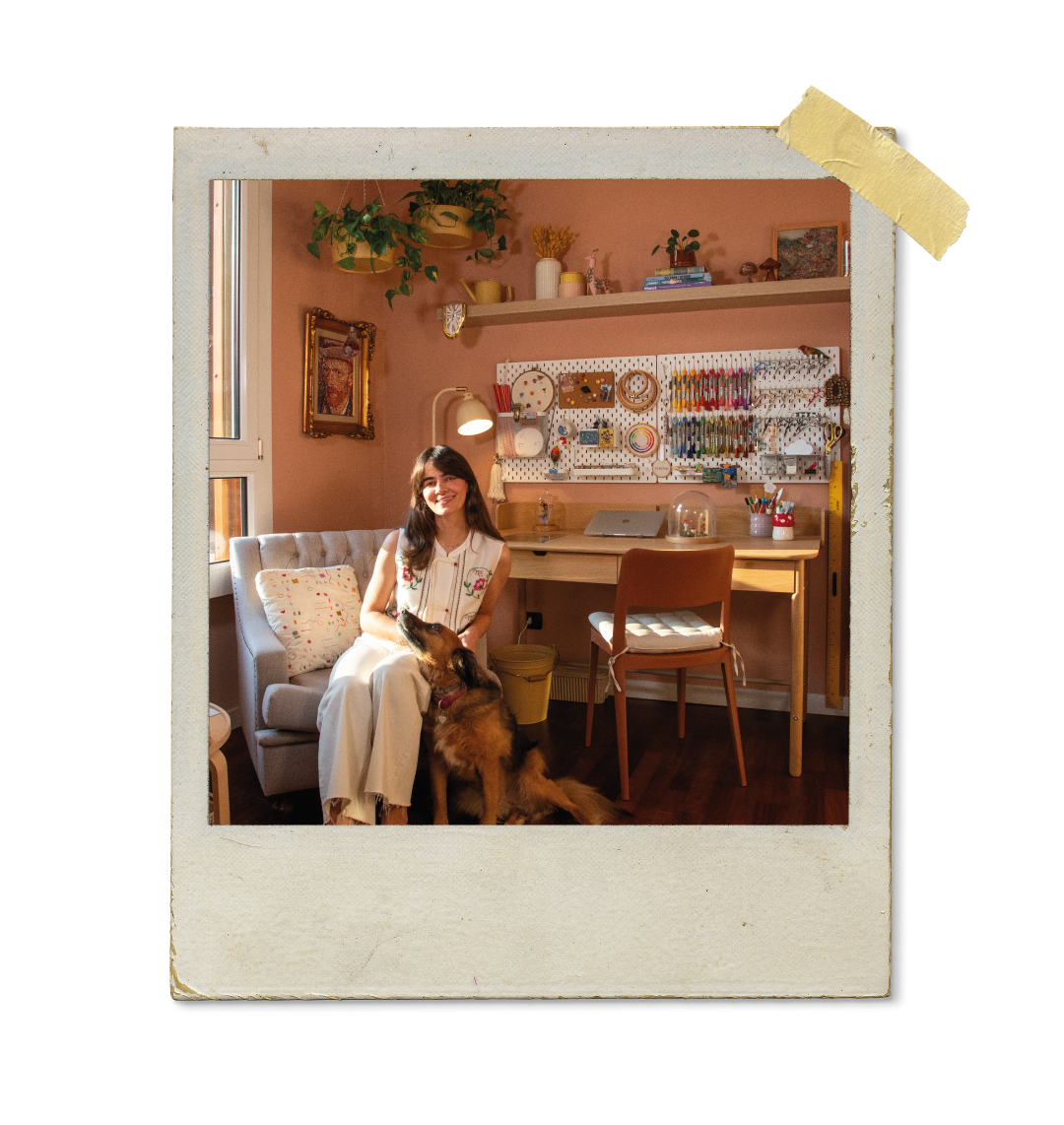 Mulher e cão sentados juntos, numa foto com um fundo de artesanato e Ayeska