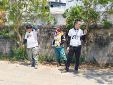 พนักงานสามคนยืนอยู่ข้างถนนใน นคร ระยอง พวกเขากำลังมองอะไรบางอย่าง