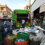 พนักงานเก็บขยะกำลังทำงานกับรถเก็บขยะในตลาดสด พร้อมถังขยะมากมาย นคร ระยอง