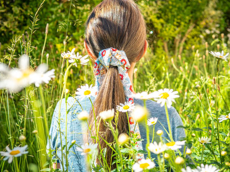 woman in a wildflower meadow wearing a furoshiki hair tie