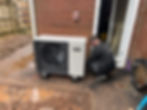 Technician working on an air source heat pump