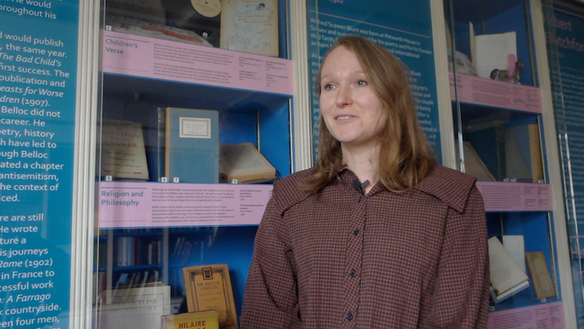 Nikki is standing in the library, in front of books written by local authors,