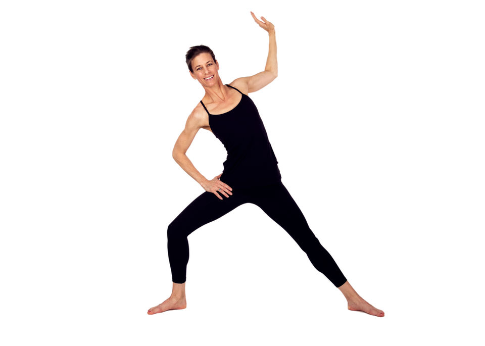 Shannon Foley, owner of Encore Pilates in Gainesville, FL, striking a confident Pilates pose. Showcasing strength, balance, and the art of mindful movement in a professional studio environment.