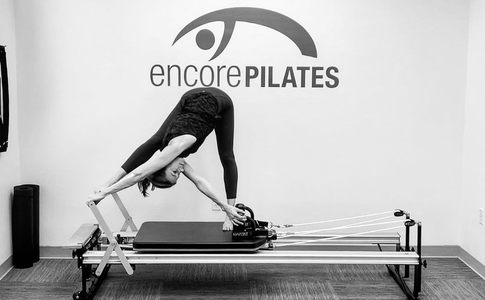 Owner Shannon Foley using Pilates Reformer equipment at Encore Pilates in Gainesville, FL. Demonstrating a strength-building exercise to improve core stability, flexibility, and overall fitness in a professional studio setting.