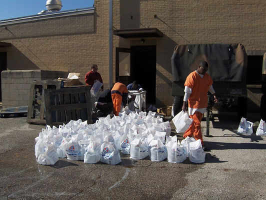 Staff staging bundles of filled AquaBag emergency water containers outside a facility