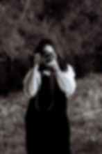 Woman looking through the viewfinde taking a foto outside of a camera while taking a photo outside