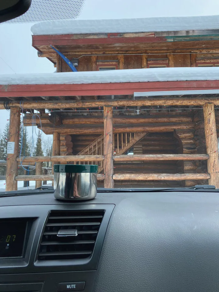 Drinking coffee from a thermos in the car