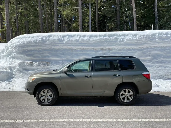 Toyota Highlander in front of a tall snow berm, near Crater Lake