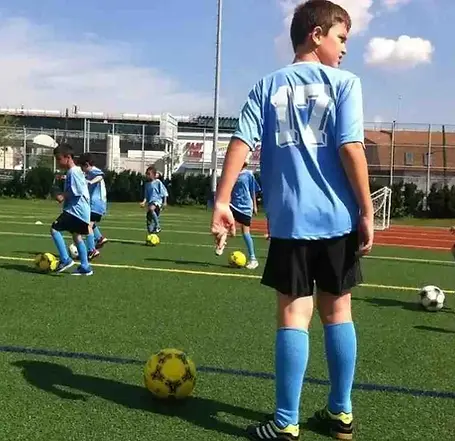 Alba FC small group soccer training Bronx with young players practicing footwork and dribbling drills on a professional turf field.