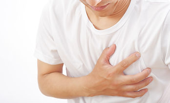 胸を苦しそうにおさえる男性
