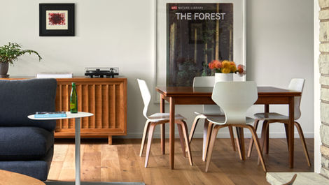 a poster of the forest hangs above a dining table