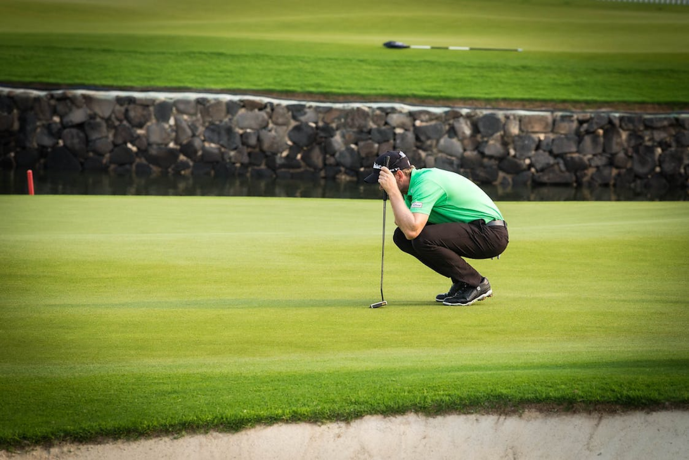 Golfer concentrating over a pressure putt during a competitive golf tournament