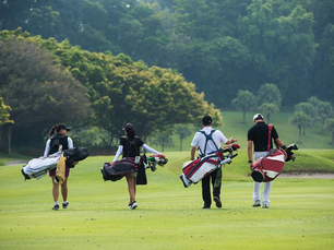 Group of junior golfers playing on a golf course during a round, representing young athletes pursuing college golf recruiting opportunities