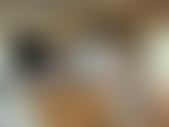 Star Trek-themed living room featuring a light gray U-shaped sectional, glass coffee table, wall-mounted TV, and decorative mural of the Starship Enterprise doors labeled "NCC-1701-A" with crew names above.