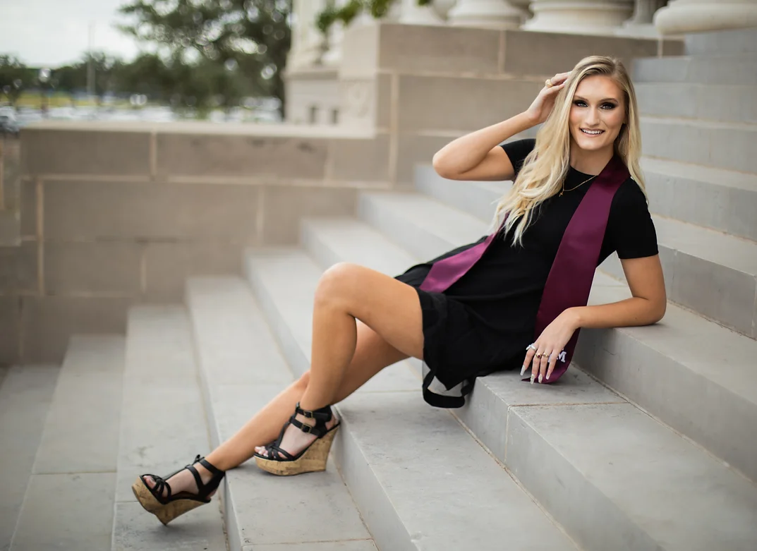 Young woman smiling sitting on white steps