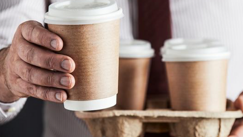 Ruka s kelímkem na kávu