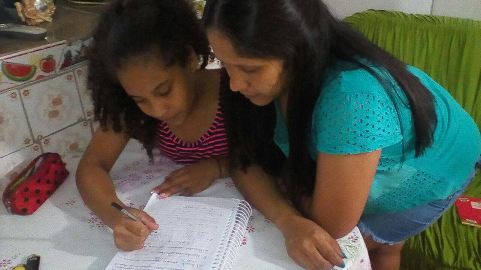 Celita auxilia a filha Mikaele nas tarefas escolares