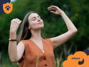 Woman in an orange top enjoys nature with eyes closed, arms raised. Greenery in background. Logos with paw prints and "Wilsons Health" visible.