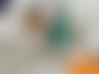 Two women converse in a clinic, one in scrubs holding a clipboard, the other sitting and smiling. A dog rests on the floor nearby.