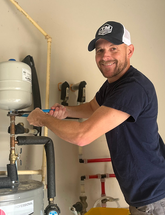 Male plumber working on a water heater