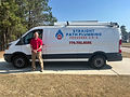 Man standing outside of the driver side door of a work truck or van.jpg
