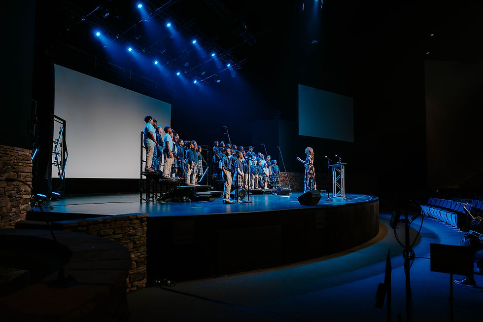 Students in a choir, singing on stage