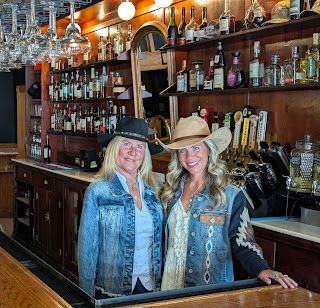 The colorful bar is the backdrop as Kim Germain and daughter Jessica take a break from work.