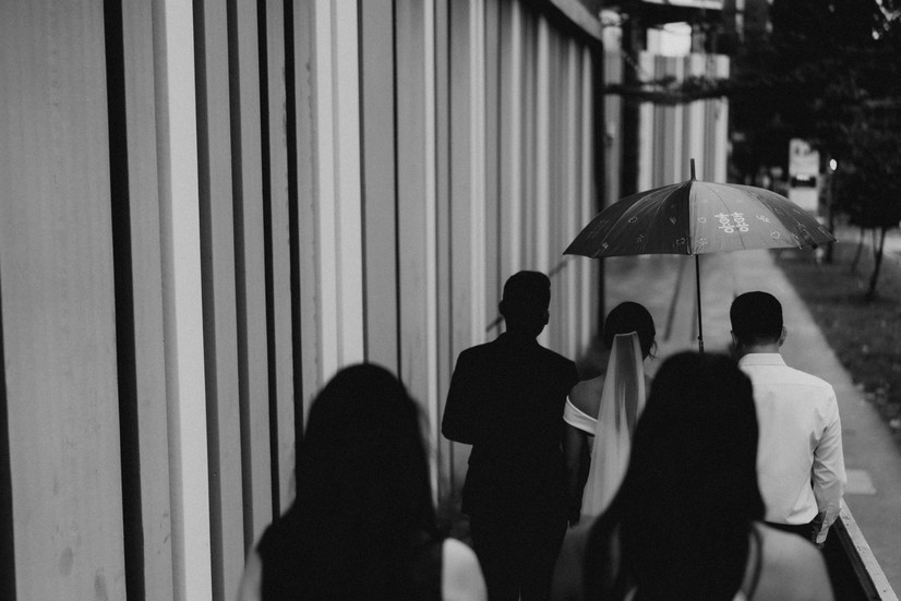 Bride and parents under red umbrella traditional wedding in Singapore