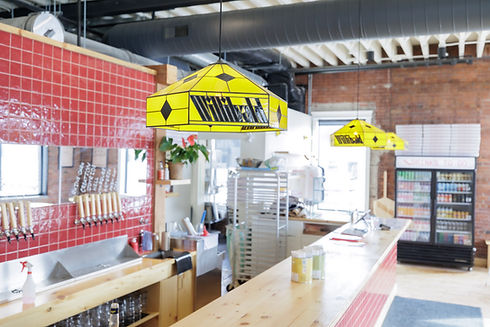 Commercial kitchen with red tiles, wood counter, and yellow lights