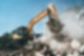 Destruction of old house by excavator. Bucket of excavator breaks concrete structure..jpeg