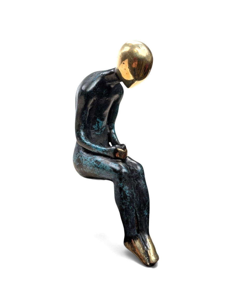 Contemplative shelf sitter figurine displayed on a furniture edge