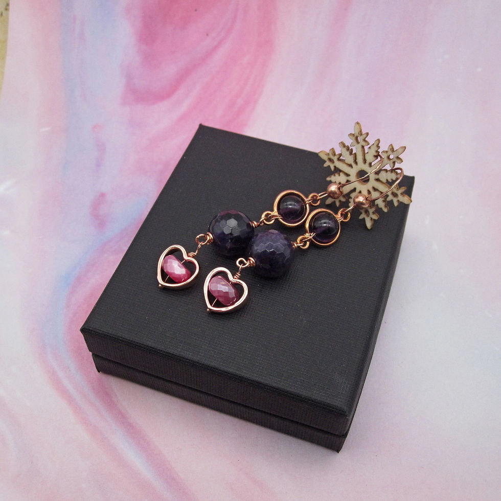 Long drop earrings with three gemstones hanging one below the other. Two amethyst and one pink moonstone in a heart frame.