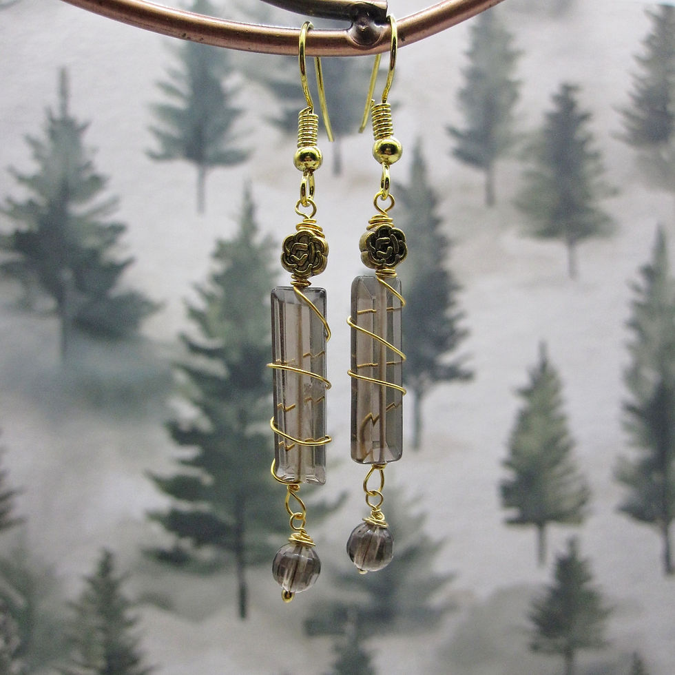 Earrings with smokey quartz column and gold plated celtic bead at top. Finished with small smokey quartz dangle bead.