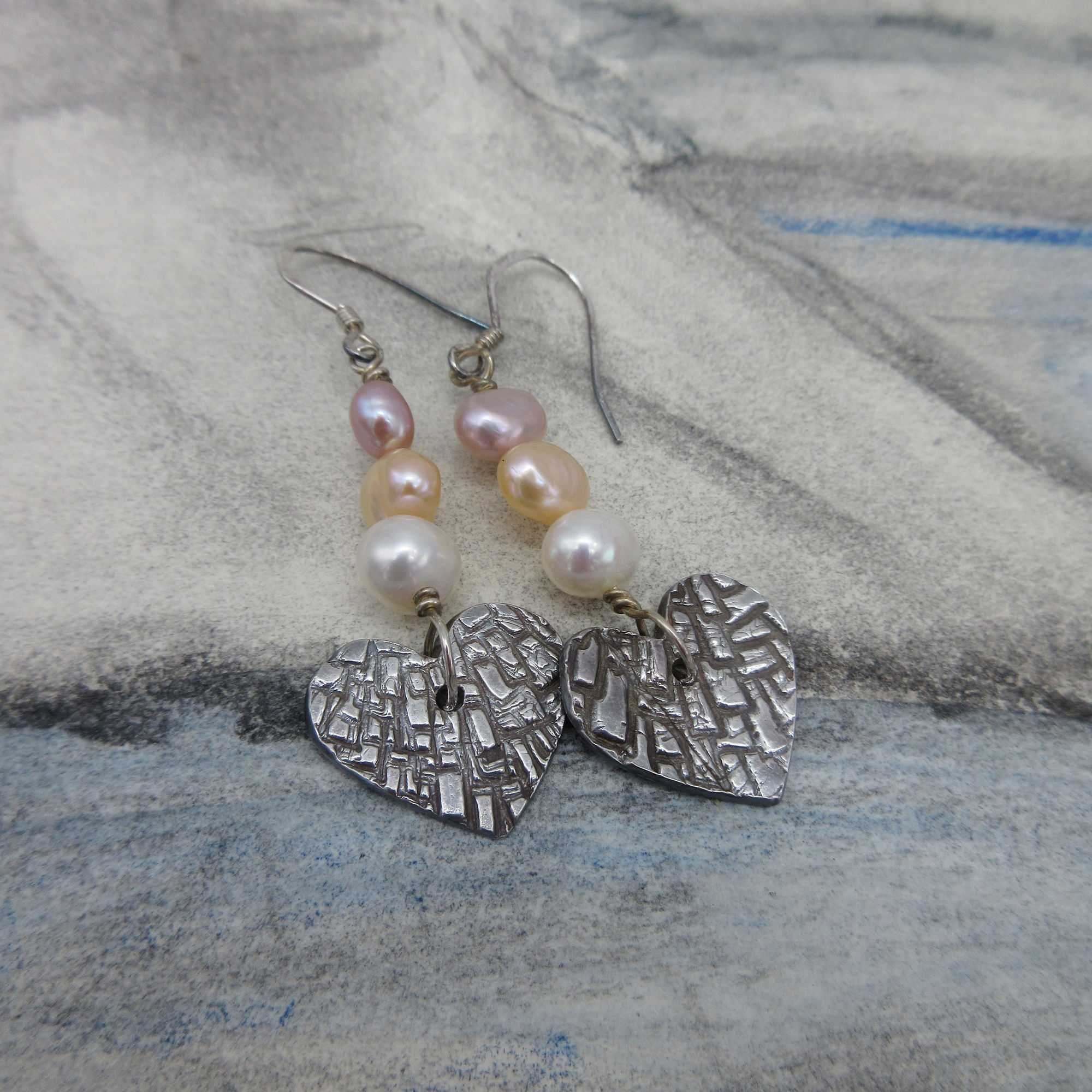 Earrings with drop of three pearls and a textured silver heart