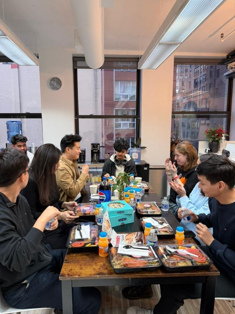 Students and staff at the NYC Global Center gather for a communal iftar, starting the meal with a moment of prayer and reflection.
