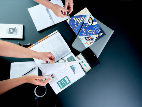 Hände blättern eine auf dem Tisch liegende Zeitschrift durch