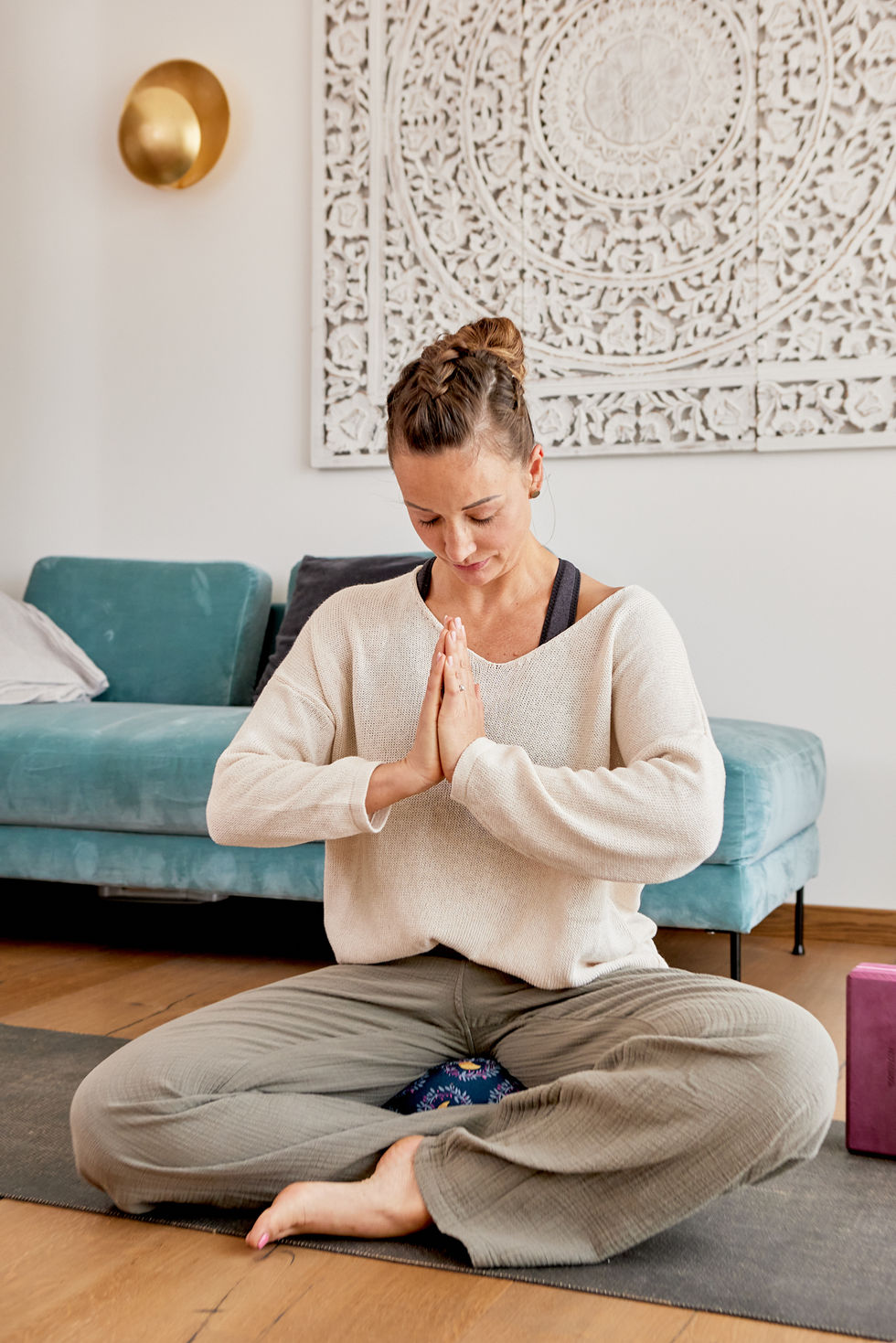 Yogalehrerin in Ruheposition am Boden sitzend