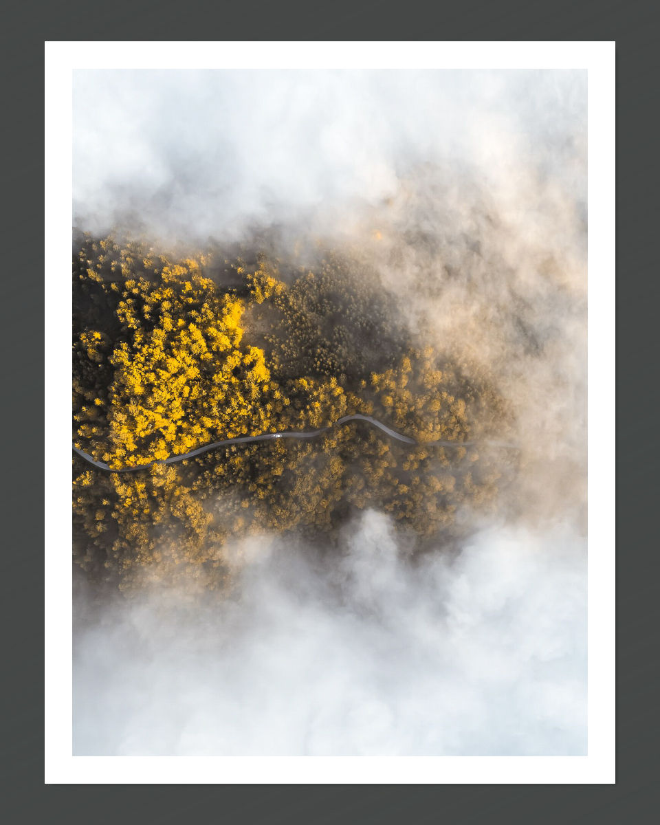 A landscape image with yellow and green hues, resembling a cloudy sky, presented on a black background.