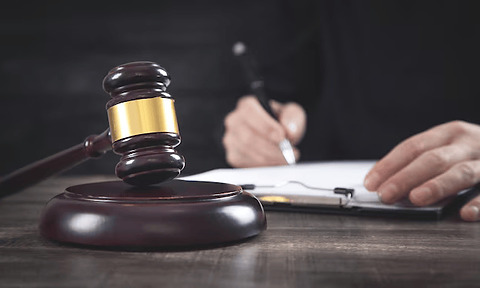 judge-gavel-table-judge-signing-document.png