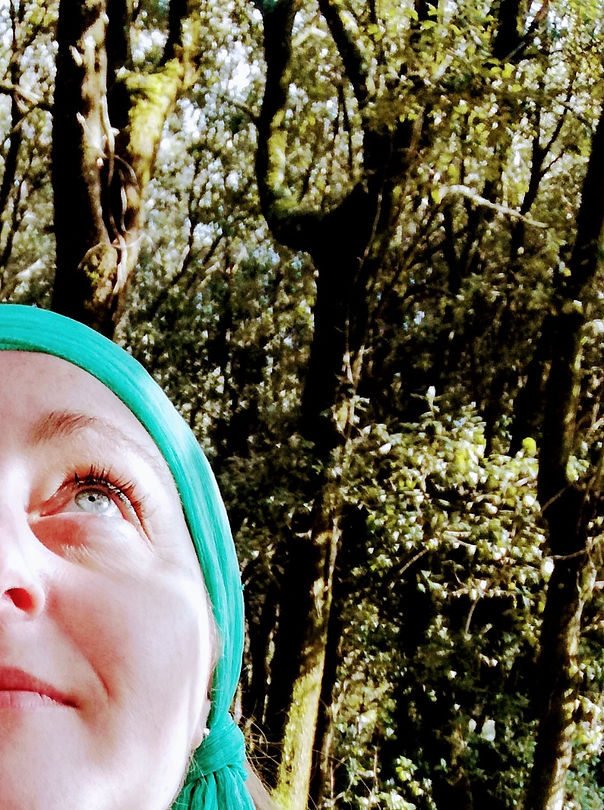 Lo sguardo di Lisa Proietti, ideatrice del brand EDU, rivolto verso il cielo, tra giochi di luci e ombre dettati dalle fronde degli alberi mosse dal vento nel suo bosco.