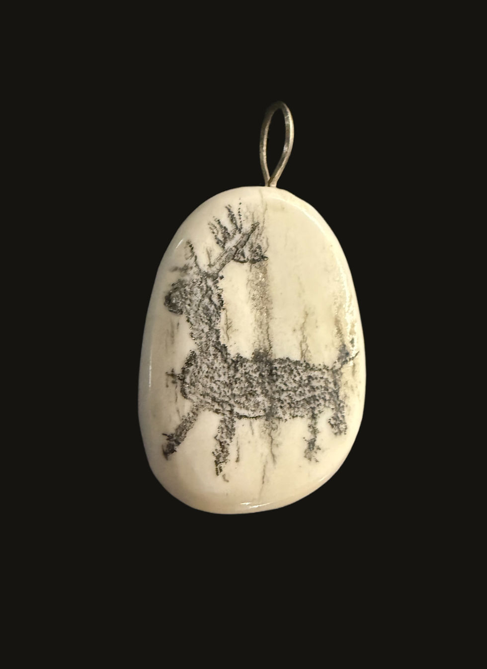 Oval pendant with reindeer etching, showcasing our craft